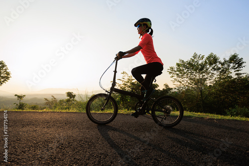 Riding folding bike on sunny mountain top road