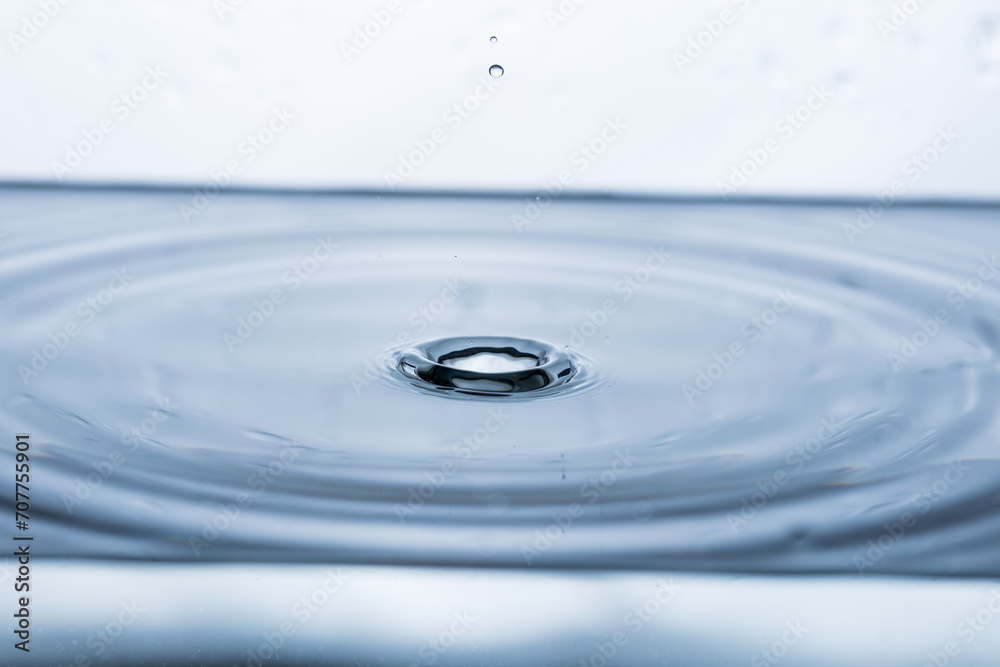 Captivating water droplet forming a splash and movement on white backdrop. Ideal for banners promoting freshness, purity, and vitality. Captivating water droplet forming a splash and movement on white backdrop. Ideal for banners promoting freshness, purity, and vitality.