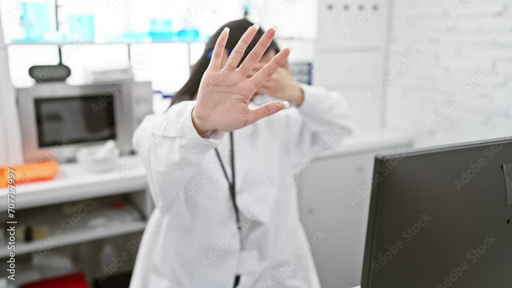 Fear-stricken young chinese woman scientist covering eyes with hand, making stop gesture, in lab. a negative and alarming concept conveyed through her expression. Fear-stricken young chinese woman scientist covering eyes with hand, making stop gesture, in lab. a negative and alarming concept conveyed through her expression.