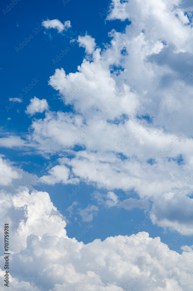 Fluffy white cumulus clouds in a blue sky on a beautiful day, natural soft background with copy space for text Fluffy white cumulus clouds in a blue sky on a beautiful day, natural soft background with copy space for text