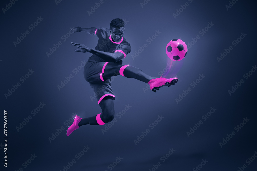 African young man, soccer player in mid-kick with selective purple coloring, illustrating movement and focus. Dynamic image of athlete during championship. Poster for sport events, game