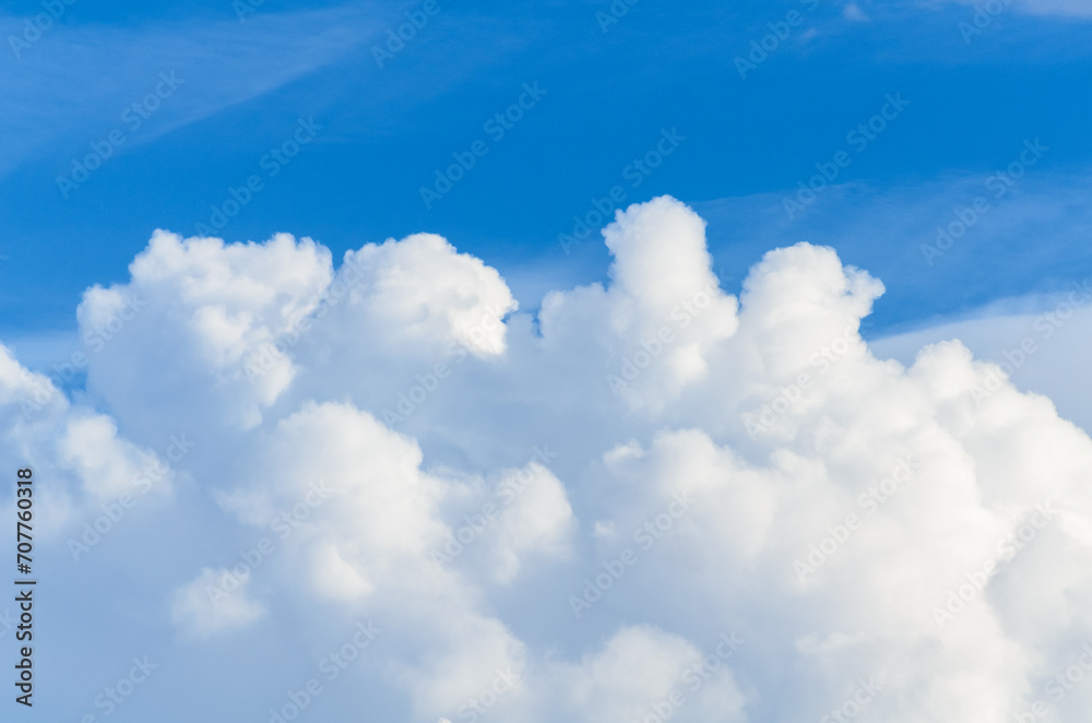 Fluffy white cumulus clouds in a blue sky on a beautiful day, natural soft background with copy space for text Fluffy white cumulus clouds in a blue sky on a beautiful day, natural soft background with copy space for text