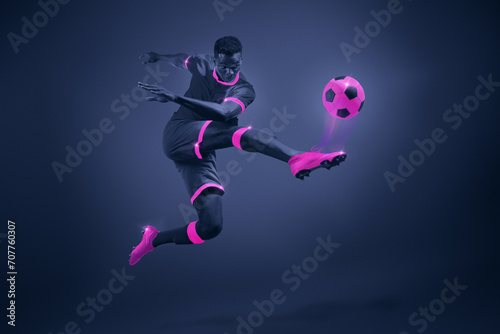 African young man, soccer player in mid-kick with selective purple coloring, illustrating movement and focus. Dynamic image of athlete during championship. Poster for sport events, game