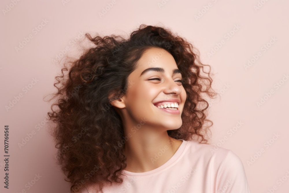 Portrait of a beautiful young woman with curly hair on a pink background Portrait of a beautiful young woman with curly hair on a pink background