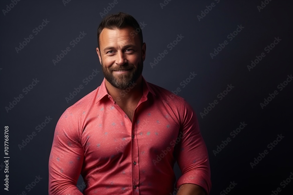 Portrait of a handsome man in a pink shirt on a dark background