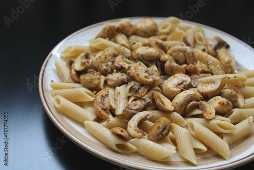 Pasta with.mushrooms and spice, dark background 