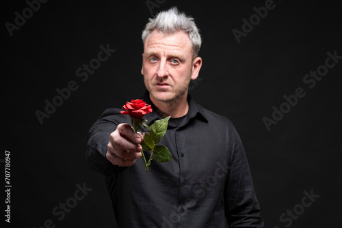 Hombre entregando una flor rosa roja photo