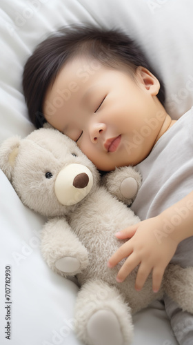 Newborn Asian baby boy sleeping with a teddy bear. Generative AI.