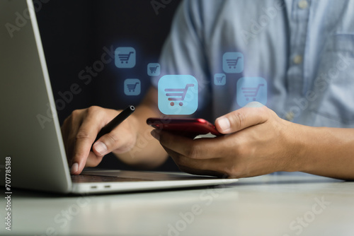 Man using phone and laptop, online shopping concept.