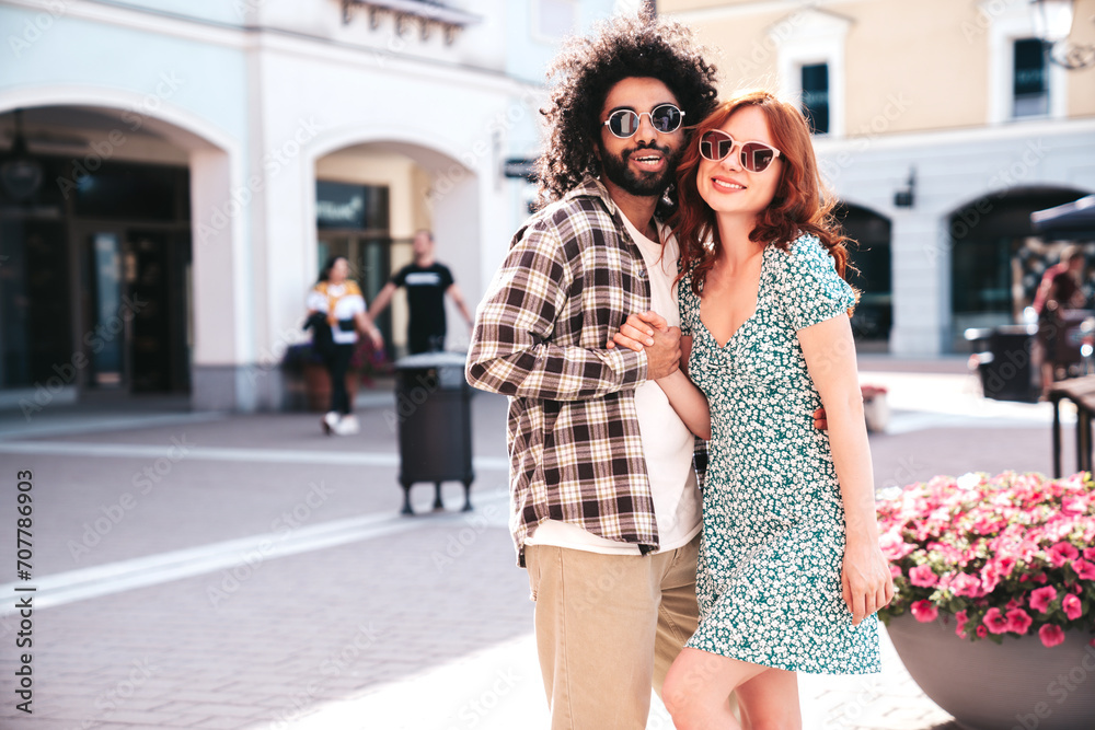 Smiling beautiful redhead  woman and her handsome boyfriend. Model in casual summer clothes. Happy cheerful family. Female having fun. Couple posing in the street at sunny day