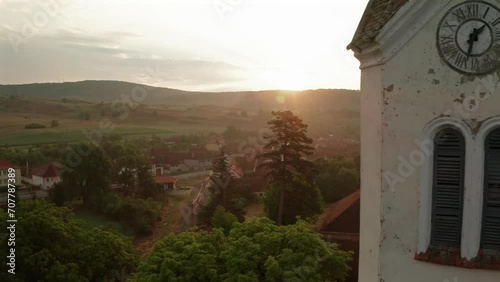 Fortified church in Transylvania. Aerial 4K video with Bunesti fortified church next to Brasov. Sunrise over Bunesti church and village. Travel to Romania.