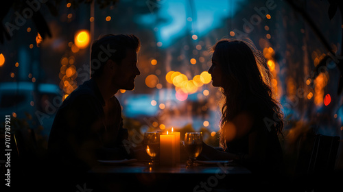Silhouette photo of a couple doing candle light dinner with bokeh background. Romantic valentine concept