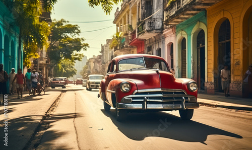 Vintage red classic car cruising on a sunny street in Havana with historical architecture and tropical vibes, capturing the essence of old Cuba © Bartek
