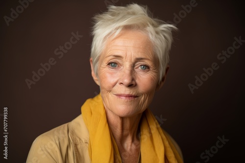 Portrait of a senior woman with blond hair on a brown background © Loli