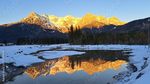 Fototapeta Naklejka Na Ścianę i Meble -  Scenic view of a snow-covered mountain reflecting on a lake in winter