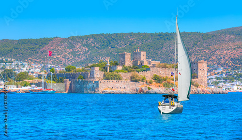 Fototapeta Naklejka Na Ścianę i Meble -  Lone white sail yact near Saint Peter Castle (Bodrum castle) and marina in Bodrum, Turkey