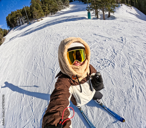 Selfie of a young woman skiing on the mountain.