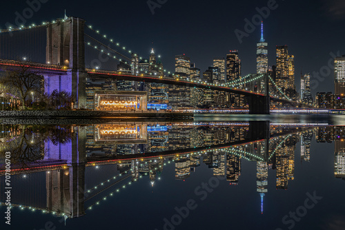 view of the brooklin bridge at night with reflections. manhattam skyline, brooklyn bridge. New York City