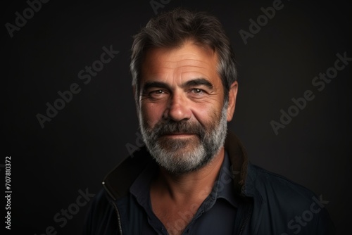 Portrait of a handsome mature man with a beard on a dark background