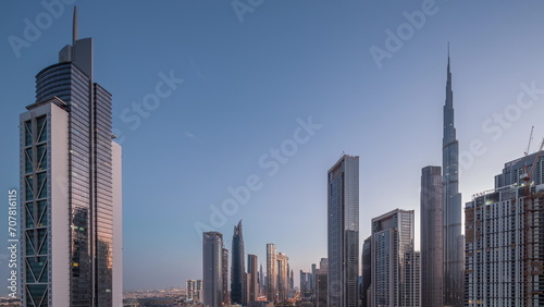 Aerial sunrise view of Dubai Downtown skyline with many towers night to day timelapse.