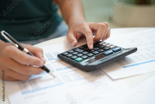 Businesswoman Accountant analyzing investment charts Invoice and pressing calculator buttons over documents. Accounting Bookkeeper Clerk  Bank Advisor And Auditor Concept.