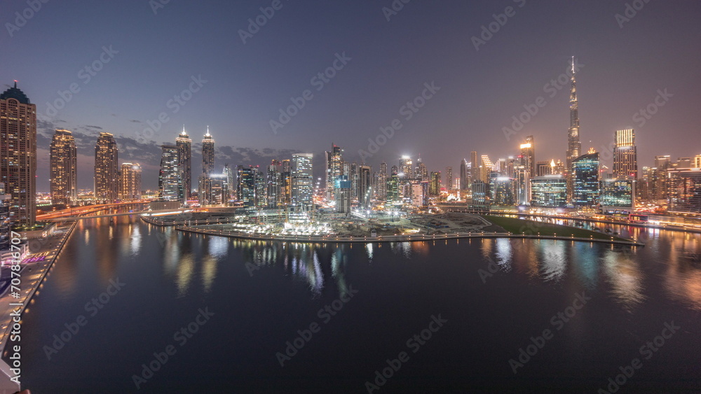 Aerial panorama of Dubai Business Bay and Downtown with the various skyscrapers and towers day to night timelapse