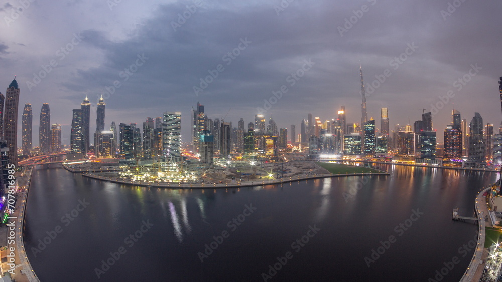 Aerial view to Dubai Business Bay and Downtown with the various skyscrapers and towers day to night timelapse