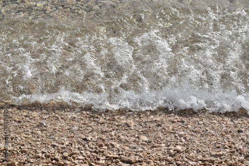 Pebble Shoreline with Crashing Waves and Clear Water