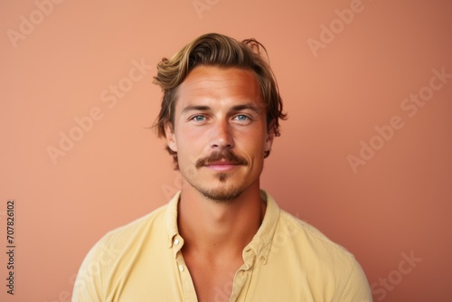 Portrait of a handsome young man looking at camera over pink background