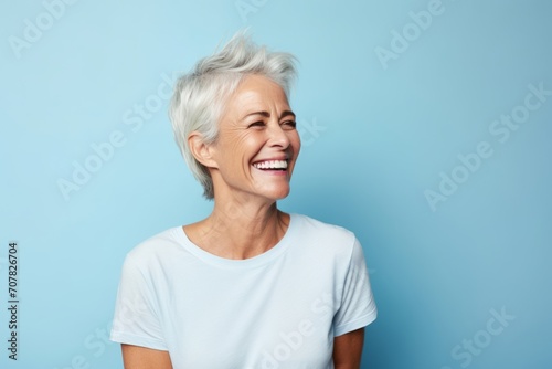 Portrait of a happy senior woman with short white hair on a blue background