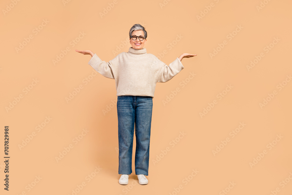 Full size photo of cheerful aged person hands demonstrate empty space proposition isolated on beige color background
