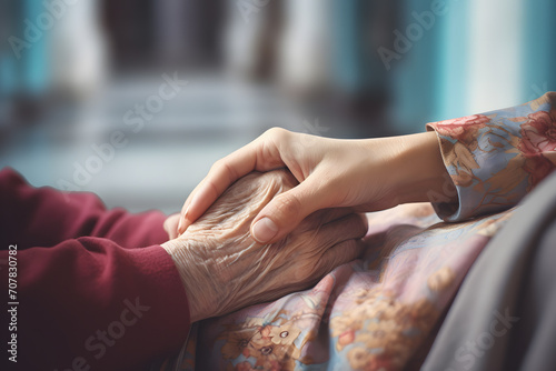 Close up of hand of young person holding hand of old person. Concept for wlderly care