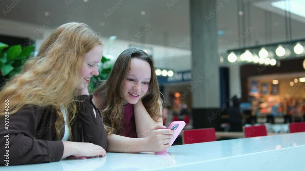 Asian girl and friend ethnic German-Thai taking smart phone selfie in department store. Asian girl and friend ethnic German-Thai taking smart phone selfie in department store.