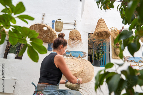 Konstfotografi Rear view of Hispanic woman weaving a basket with esparto fibers