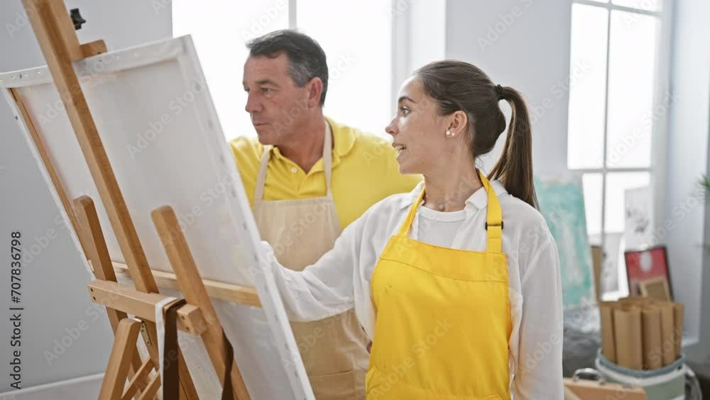 In an art studio, a man and woman artists passionately drawing together, intensively focused and calm amidst easels and paintbrushes In an art studio, a man and woman artists passionately drawing together, intensively focused and calm amidst easels and paintbrushes