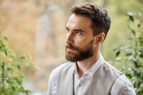 handsome concentrated leader with beard in sophisticated attire looking away, business concept