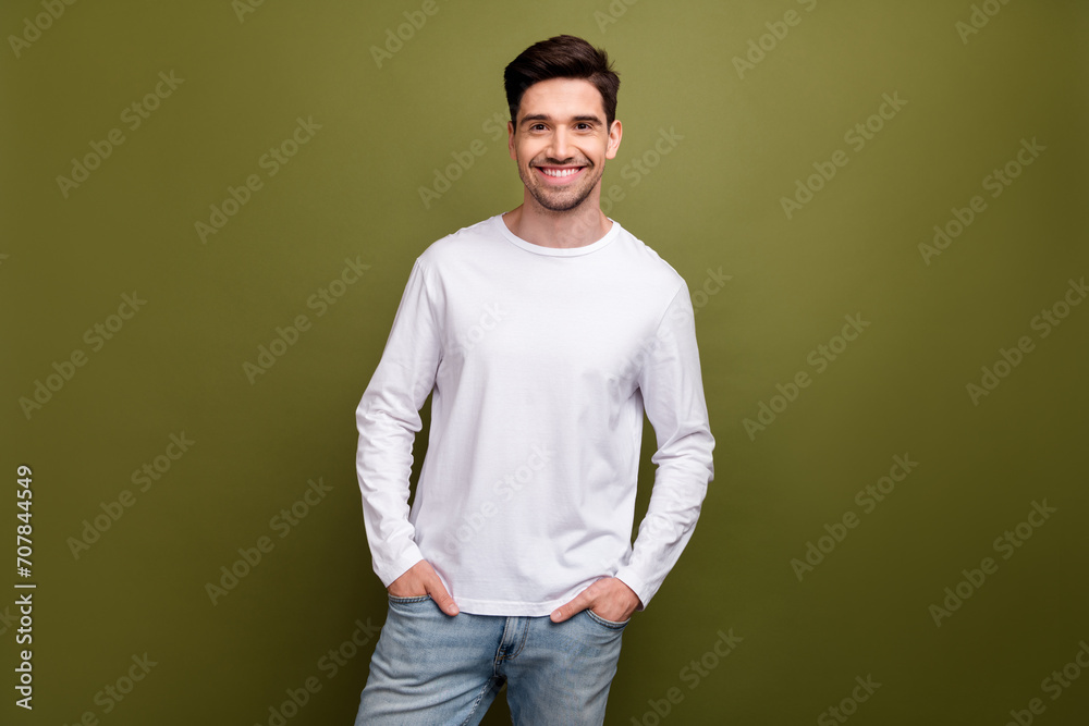 Photo of satisfied glad young person toothy smile put hands pockets posing isolated on khaki color background Photo of satisfied glad young person toothy smile put hands pockets posing isolated on khaki color background