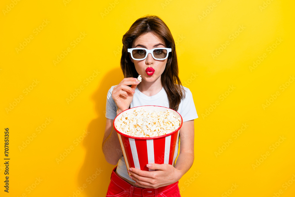 Photo of gorgeous woman with brunette hair dressed white t-shirt eat popcorn pouted lips watch movie isolated on yellow color background
