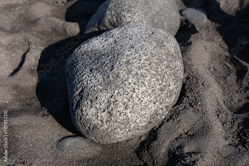 Volcanic rocks texture. Rocky beach on Canary Islands. Tenerife black beach. Small stones background. Atlantic ocean beach. Black and dark gray rocks