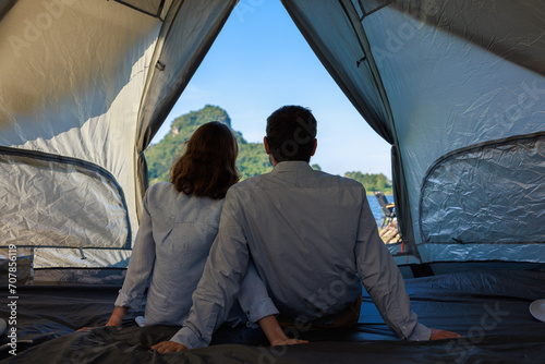 back view caucasian couple sitting inside a tent on camping trip,