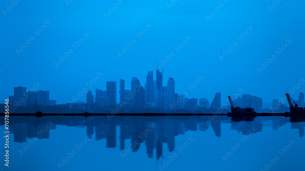 Composite image of waterfront city skyline with blue tone panoramic reflection