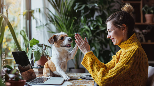 Woman in Yellow Giving High Five to Her Dog at Home Office photo