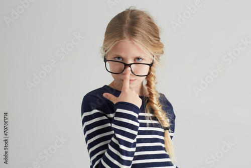 Child, portrait and glasses with serious in mockup, thought and eyewear or nose in studio. Girl, face or geek with blonde hair in fashion with vision, contemplation or smart kid by white background