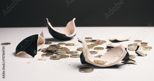 Concept photo with a broken piggy bank and scattered coins photo