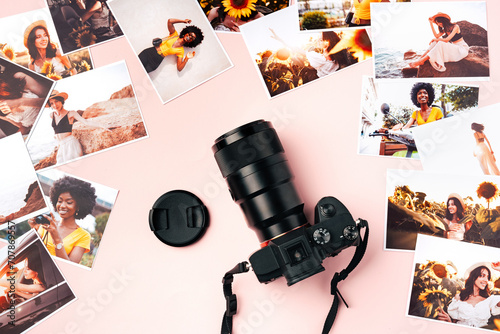 Modern photo camera with printed colorful photos on pink background