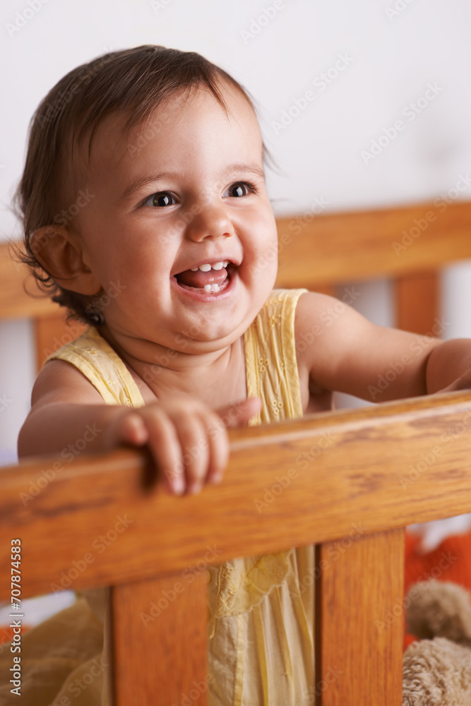 Excited baby in crib, playing with smile and fun in home, child development and care in home. Toddler girl in cot with playful face, energy and happiness in cute kids bedroom, nursery or apartment. Excited baby in crib, playing with smile and fun in home, child development and care in home. Toddler girl in cot with playful face, energy and happiness in cute kids bedroom, nursery or apartment.