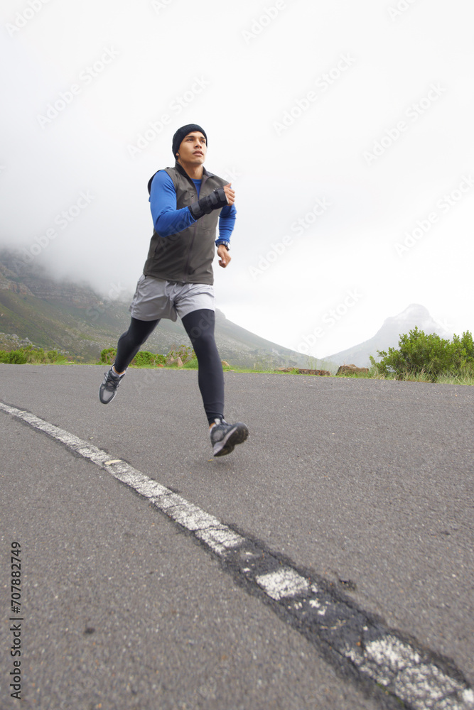Sports, fitness and man running on road in training, cardio exercise or endurance workout for wellness. Energy, runner or healthy male athlete on fast jog outdoors with speed, challenge or action
