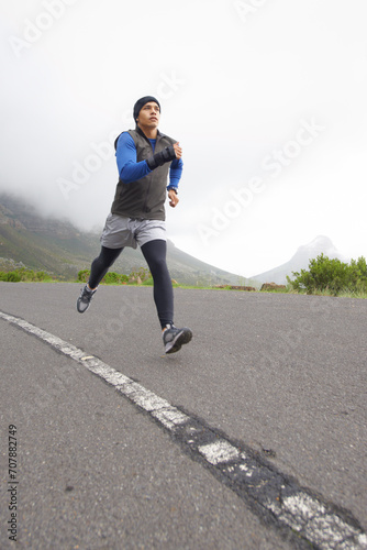 Sports  fitness and man running on road in training  cardio exercise or endurance workout for wellness. Energy  runner or healthy male athlete on fast jog outdoors with speed  challenge or action