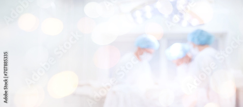 Abstract medical blurred background of operating room, patient lies on table, doctors working laparoscopy