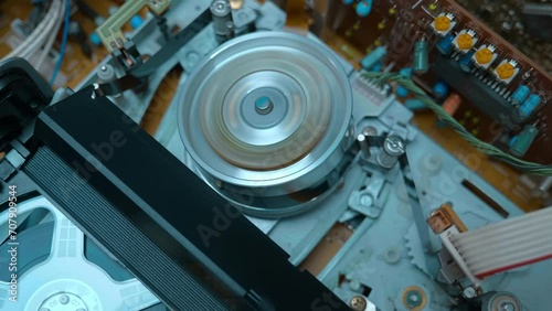 Transparent reels of magnetic tape in a video cassette rotate in a VCR to form an image in a home VCR. Shot in motion. Closeup. Macro. Shallow depth of field